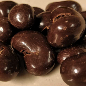 Tummalla suklaalla kuorrutettuja cashewpähkinöitä.