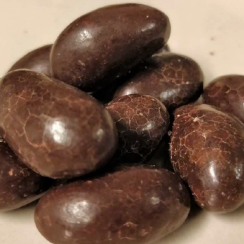 Tummalla suklaalla kuorrutettuja parapähkinöitä.